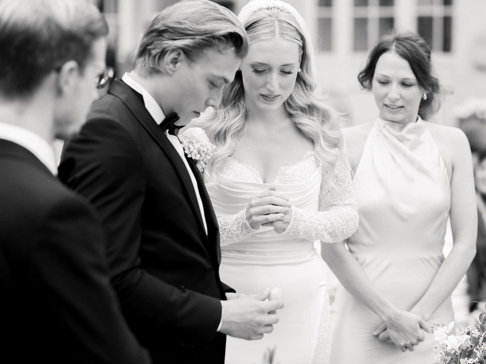 Wedding couple exchanging rings during outdoor ceremony at Schloss Kartzow in black and white