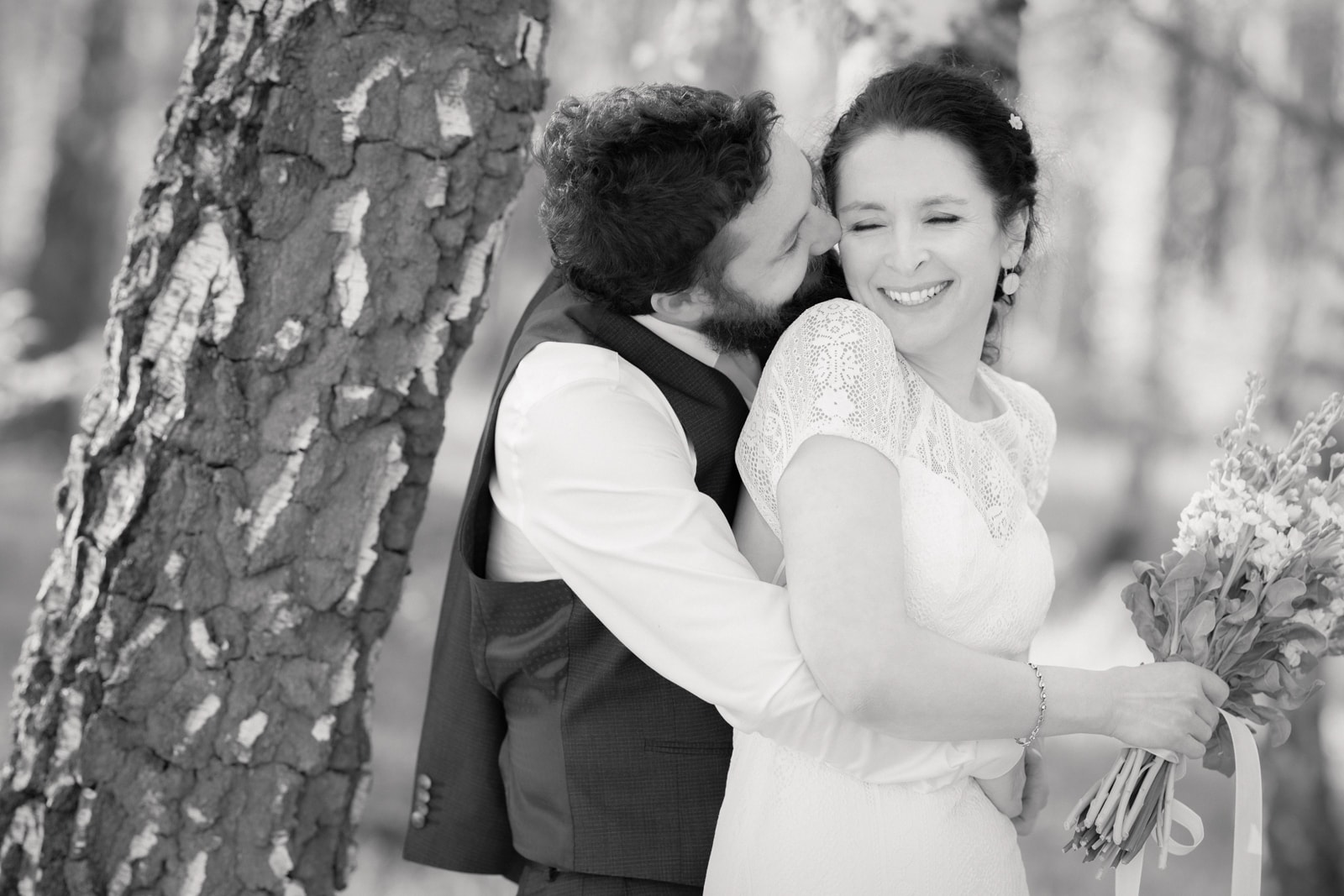 Wedding couple embracing under trees during park wedding