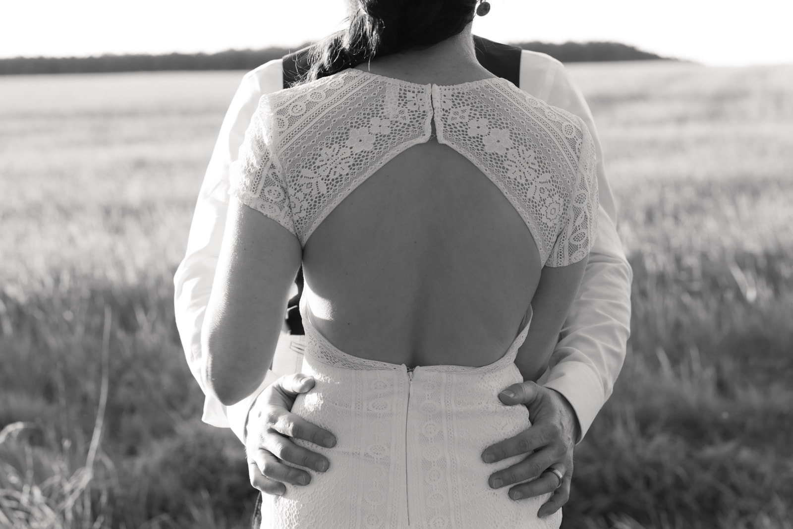 Wedding couple from behind overlooking water landscape during wedding