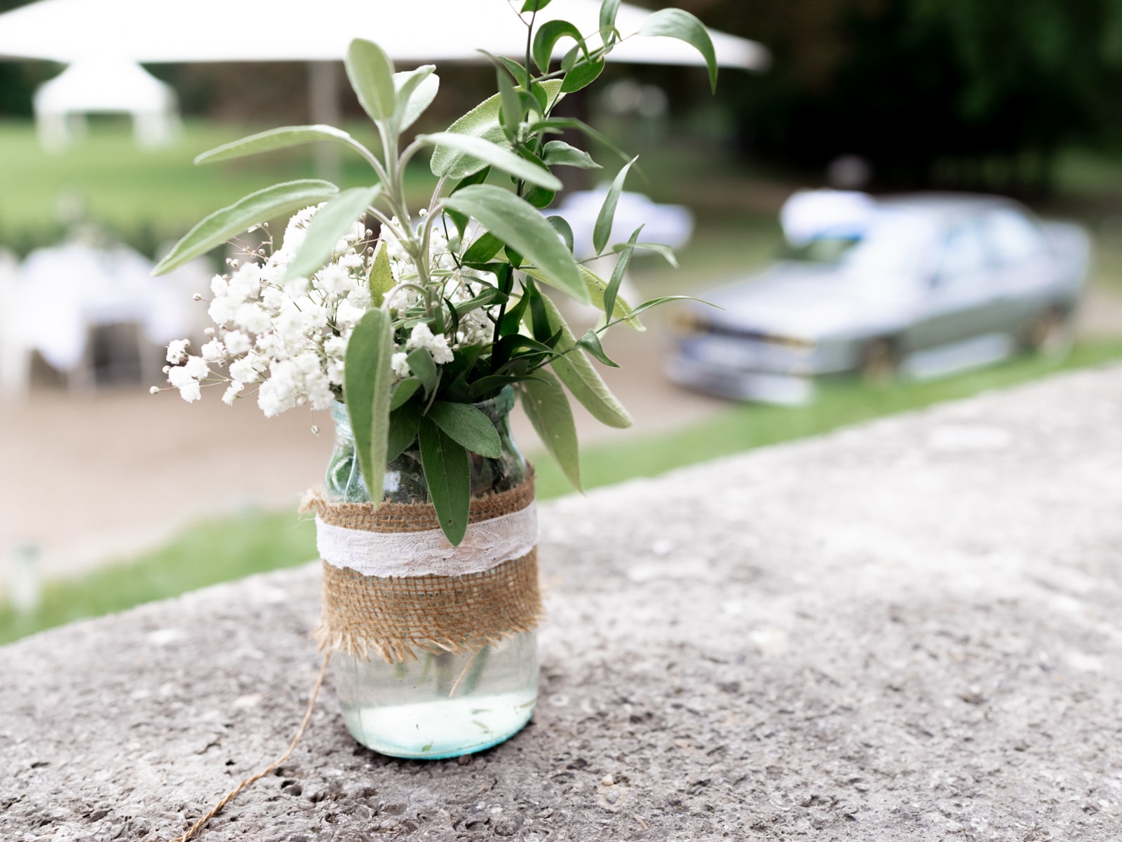 Vintage flower vase with baby's breath and burlap ribbons at Schloss Kartzow wedding