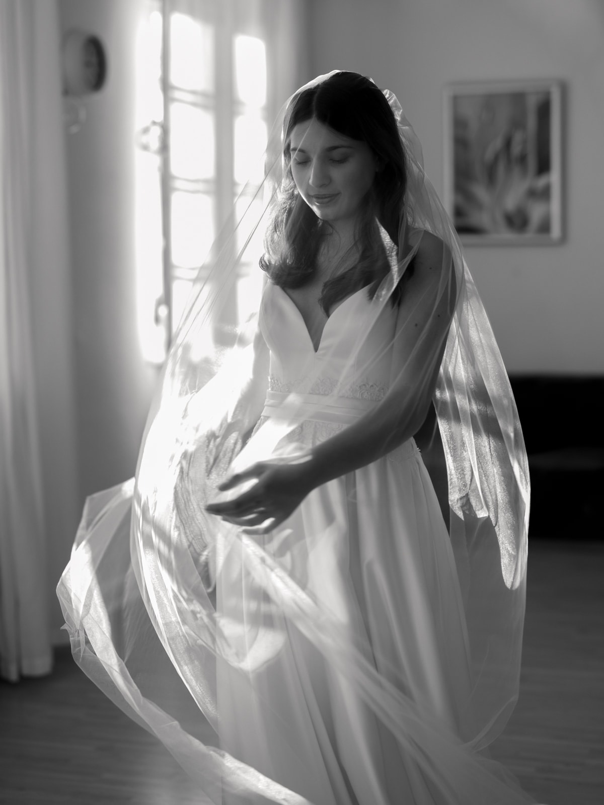 Bride in motion with flowing veil in black and white portrait