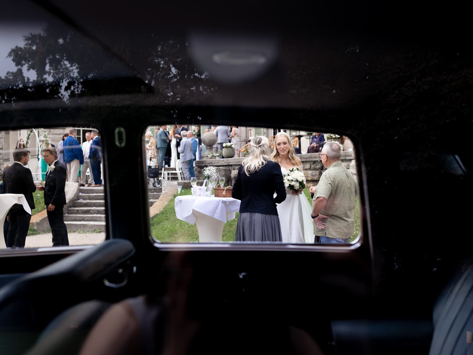 Hochzeitsgäste durch Oldtimer-Fenster bei Hochzeit Schloss Kartzow