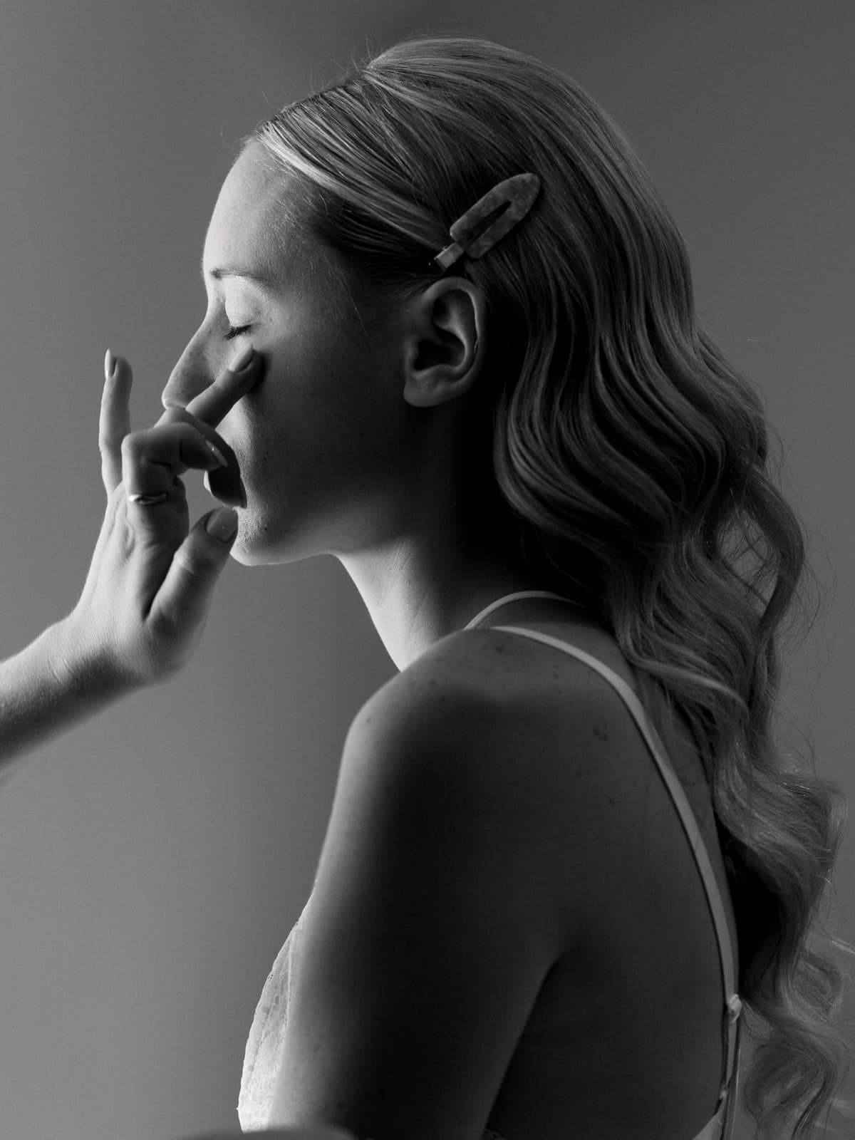 Braut in Hochzeitskleid schaut zur Seite während der Getting Ready Vorbereitungen, Schwarzweiß Hochzeitsfotografie Schloss Kartzow