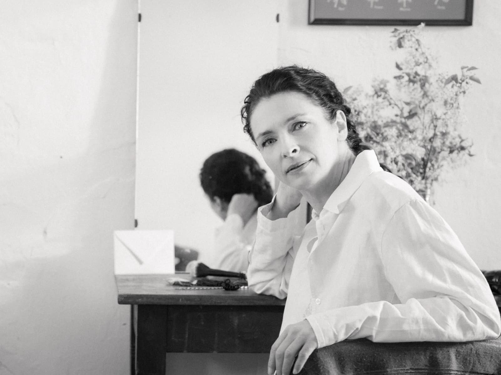 Braut schminkt sich mit Handspiegel in rustikalem Zimmer