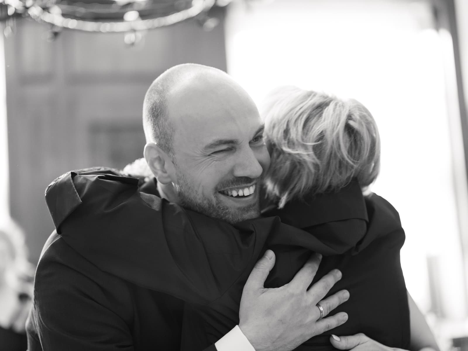 Bräutigam umarmt herzlich einen Gratulanten nach der Hochzeit