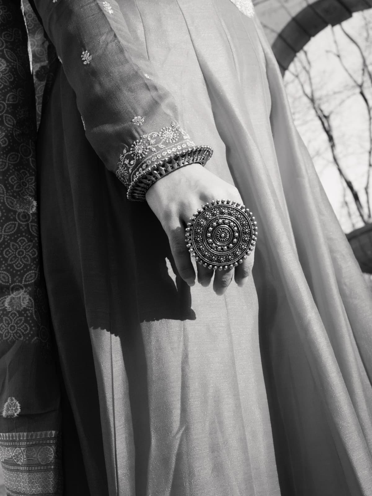 Nahaufnahme von traditionellem indischen Goldschmuck und besticktem rotem Stoff